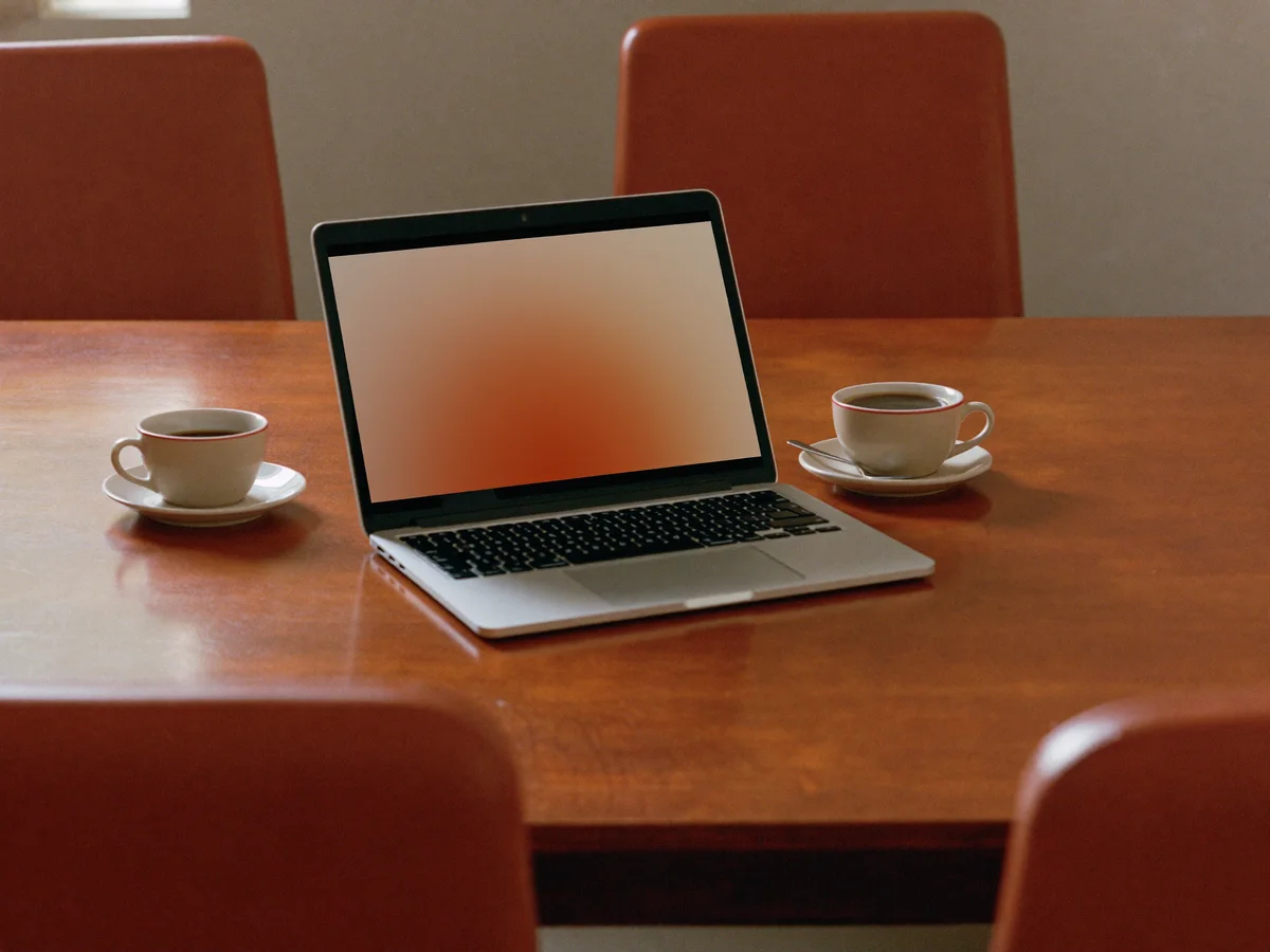 Sfeerbeeld: keukentafel met twee koffiekopjes en laptop (illustratief)